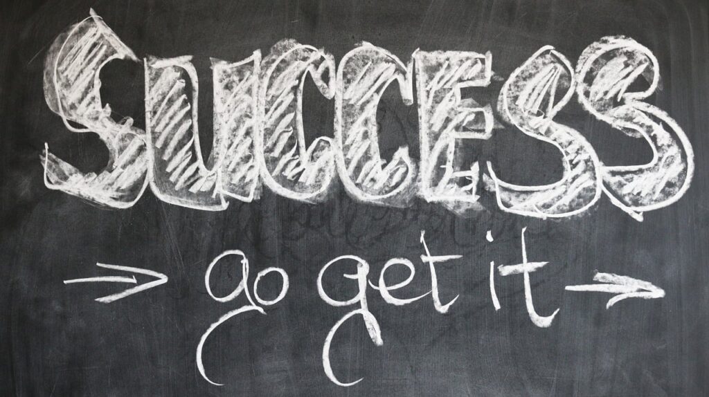 A word handwritten using chalk saying "SUCCESS, go get it".